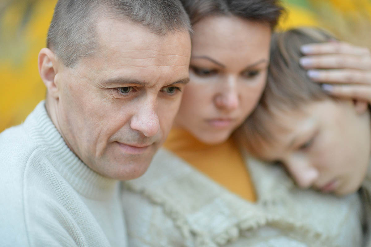 Portrait of a sad family of three on the nature. Don't face the complexities of probating an estate in Missouri alone. Learn why hiring an estate planning attorney can save you time and headaches.